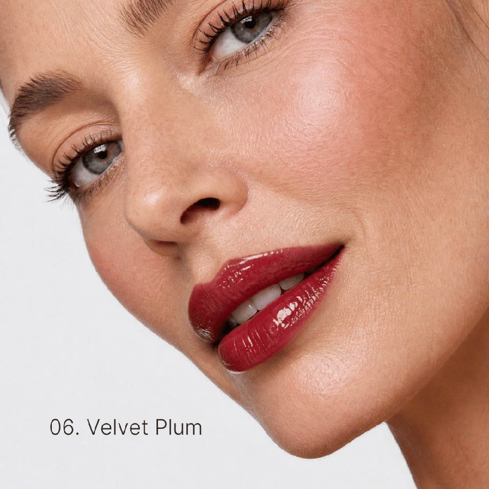 Glänzender, kirschroter Lippenstift auf den Lippen einer Frau. Farbnummer 06, "Velvet Plum".