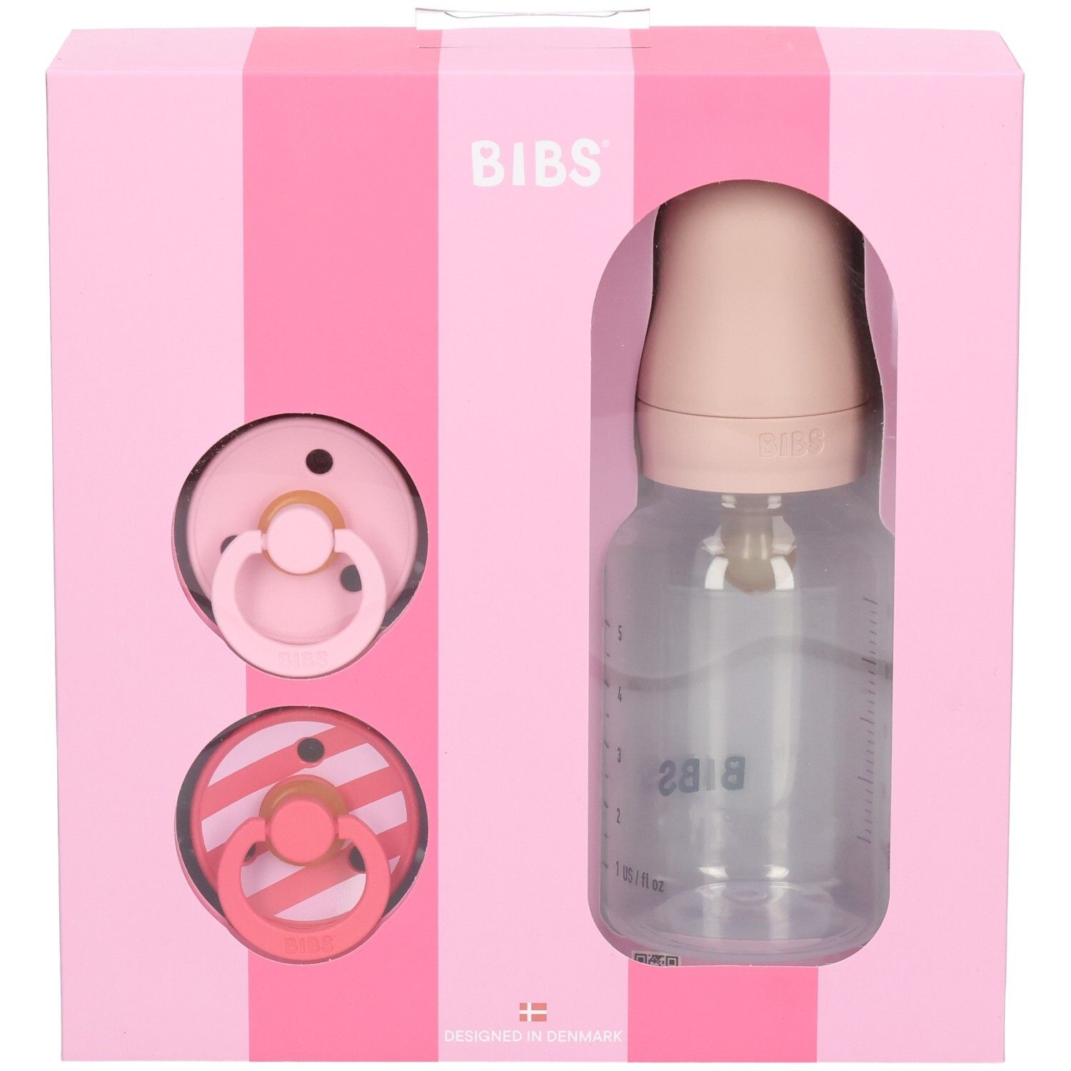 Rosa Geschenkbox mit Schnullern und Flasche. BIBS-Logo. Transparente Flasche mit Messskala. Zwei Schnuller.