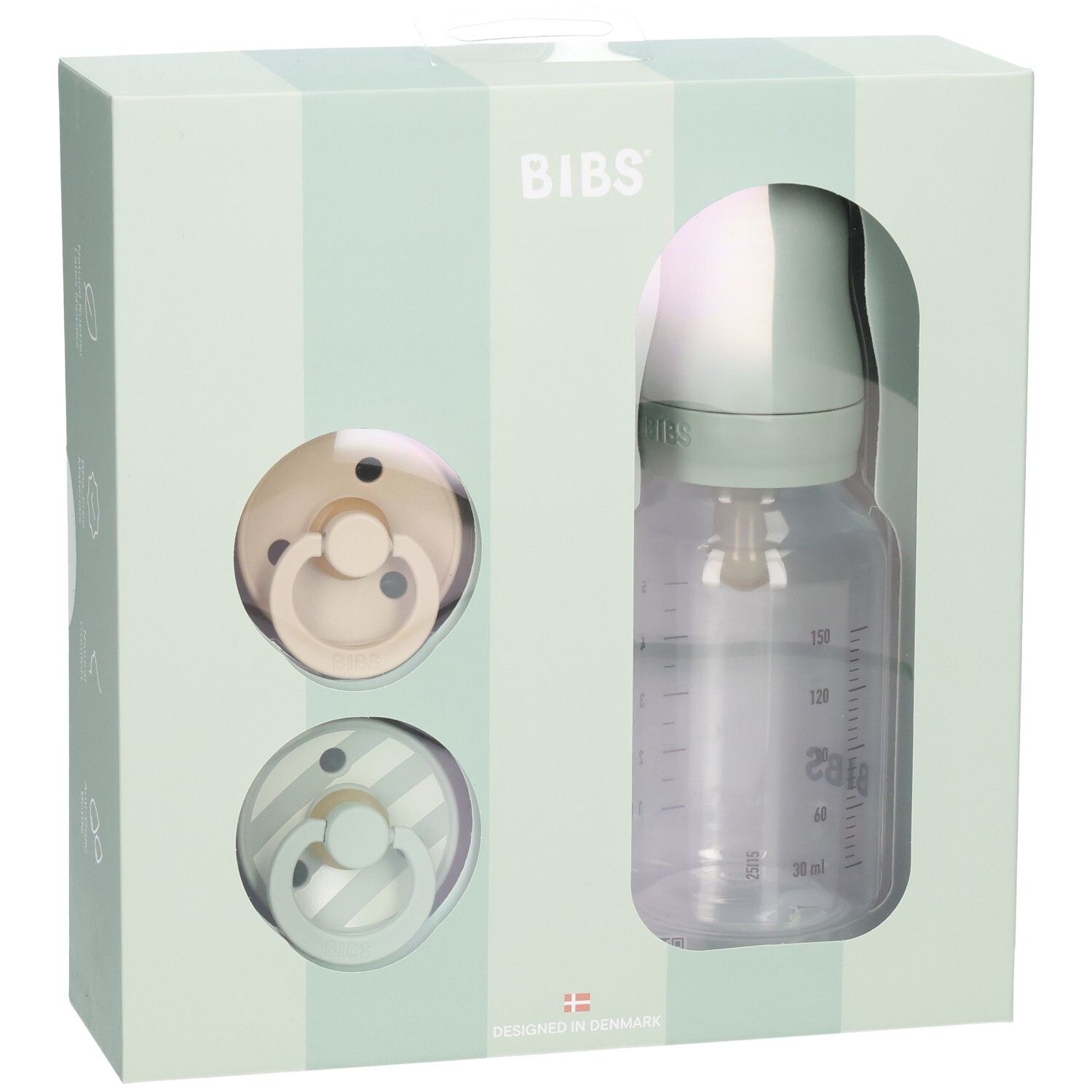 Coffret cadeau avec deux sucettes et un biberon dans une boîte. Le biberon a une échelle de mesure.