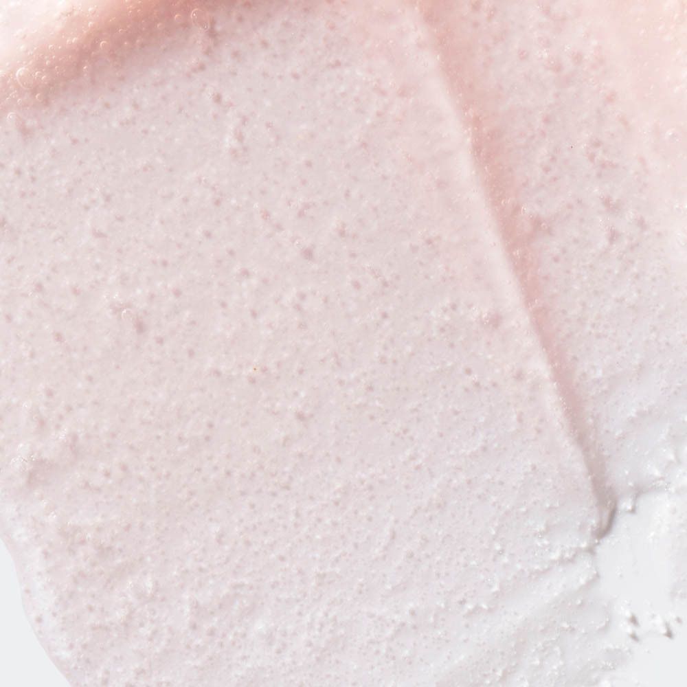 Rosa Creme mit feinen Bläschen, auf einer Oberfläche verteilt.