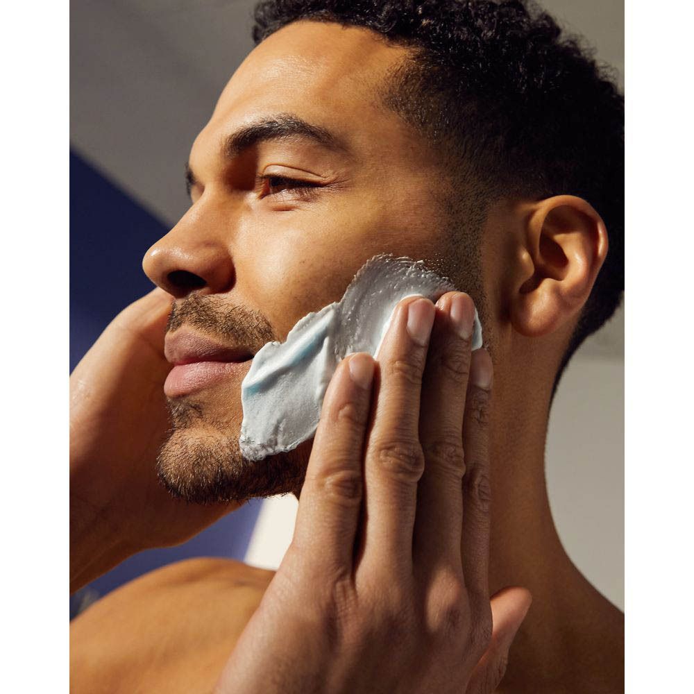 Homme se rasant. Visage recouvert de gel à raser. Mains tenant le visage.