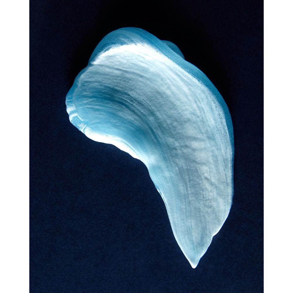 Tache bleue de gel à raser sur fond sombre. Surface lisse et brillante.