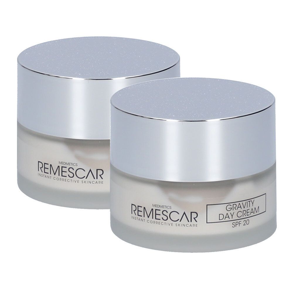 Deux pots de crème de jour Remescar Gravity, légèrement décalés, avec couvercles argentés et indication SPF 20.