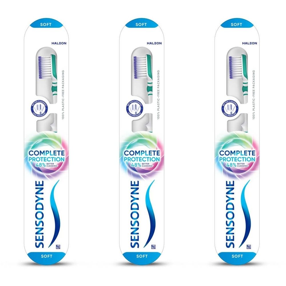 Trois brosses à dents dans leur emballage. Inscription: SENSODYNE Complete Protection. Soies bleues et blanches, manche blanc.