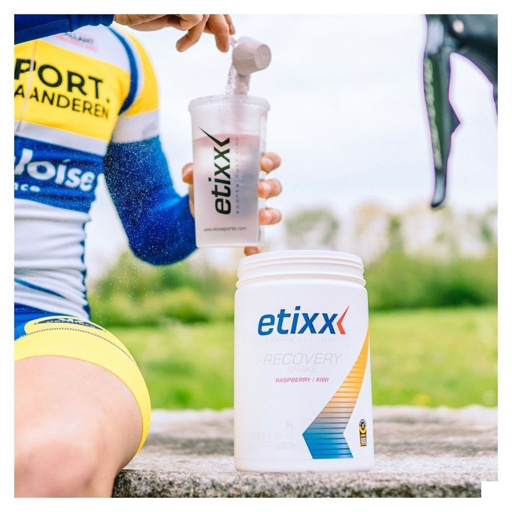 Person bereitet Etixx Recovery Shake zu. Weißer Behälter mit Etixx-Logo und Aufdruck.