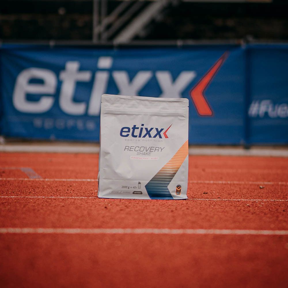 Ein Beutel Etixx Recovery Shake Schokolade auf einer Laufbahn.