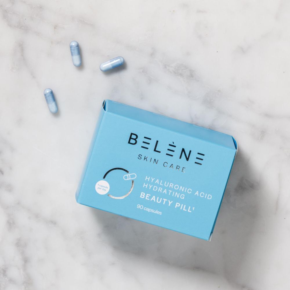 Une boîte de pilules de beauté à l'acide hyaluronique BELENE Skin Care, 90 gélules, avec trois gélules à côté.
