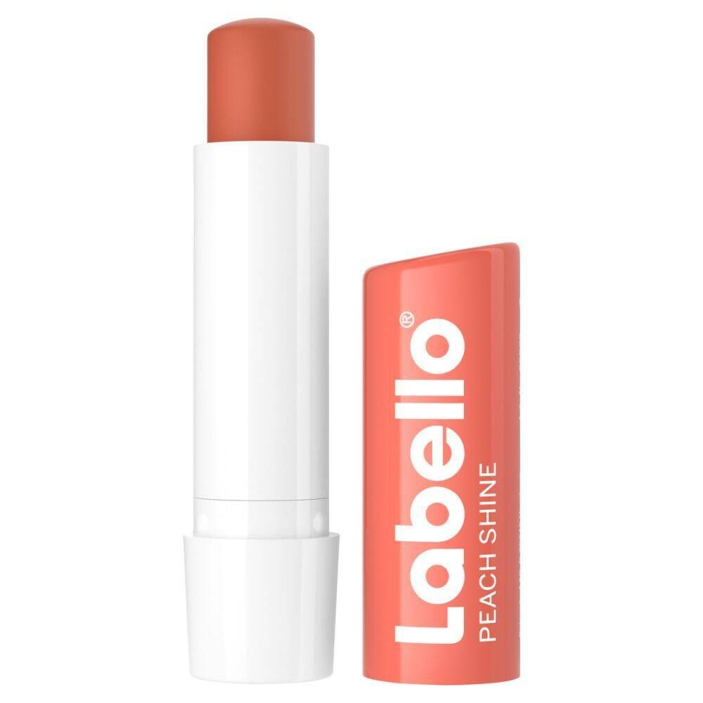 Stick de soin pour les lèvres Labello Peach Shine, ouvert. Étui rose, bâton blanc. Inscription Labello Peach Shine.