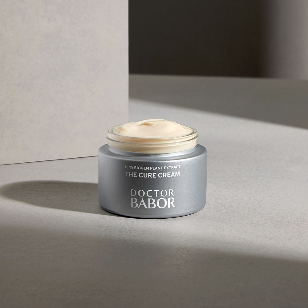 Silberfarbener Creme-Tiegel mit Creme gefüllt. Aufschrift: THE CURE CREAM, DOCTOR BABOR.