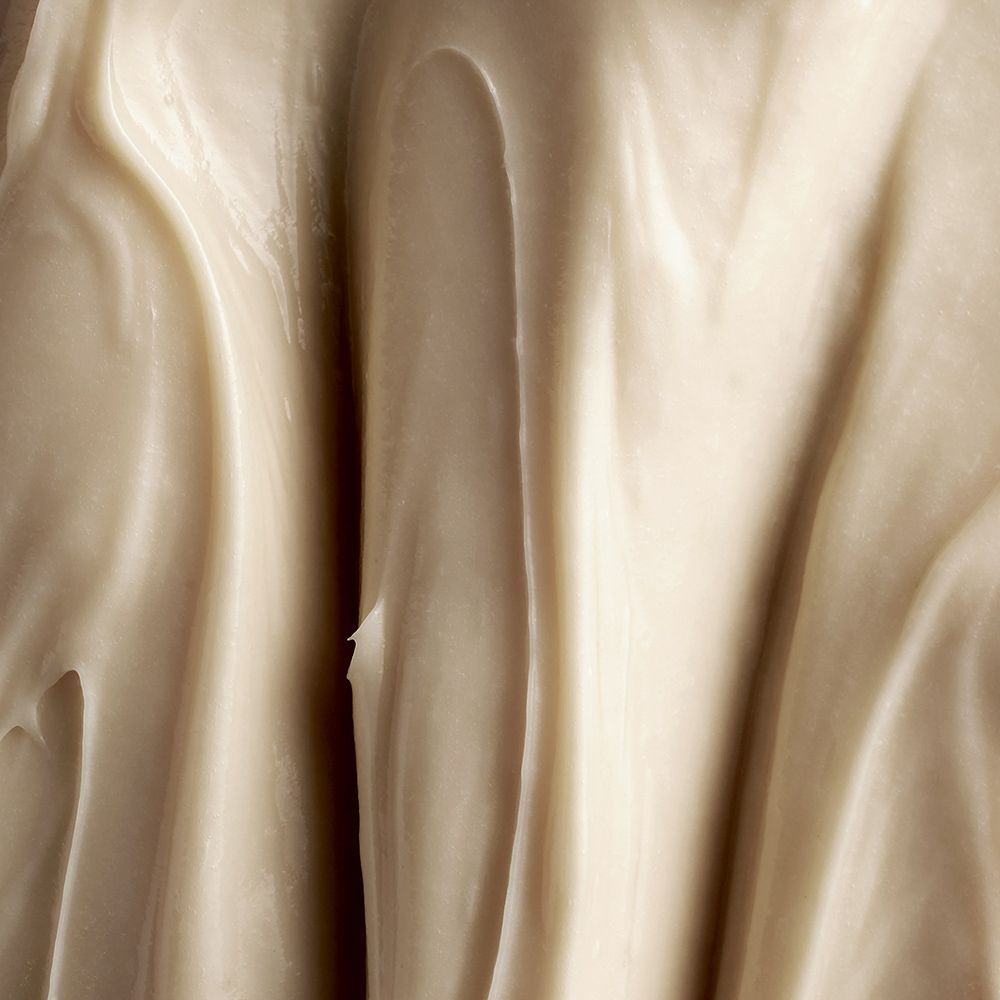 Nahaufnahme von cremiger, beiger Creme. Wellenförmige Textur.