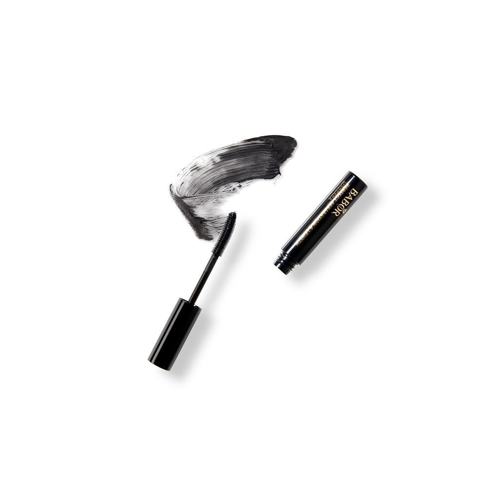 Brosse et tube de mascara noirs à côté d'une trace de mascara noir.