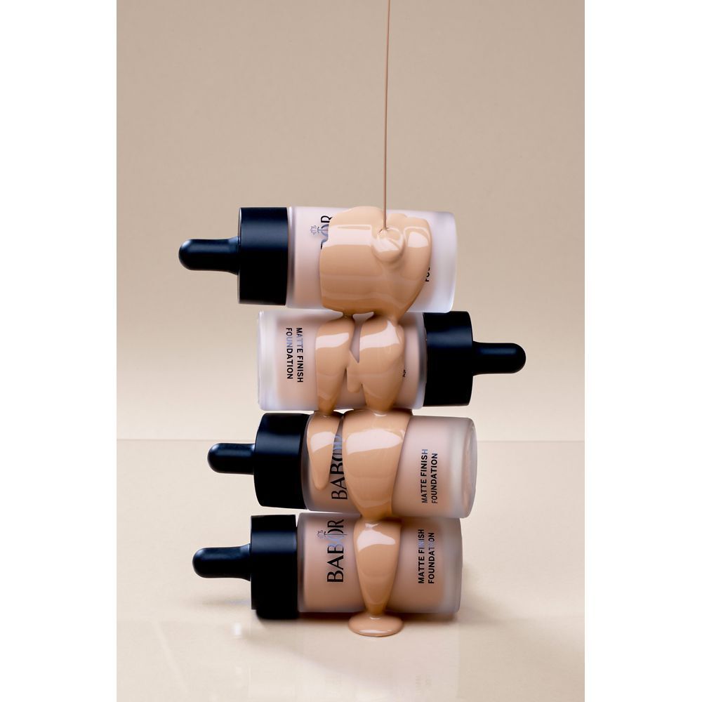 Foundation-Fläschchen werden mit Foundation übergossen. Mehrere Flaschen. Beige Foundation.