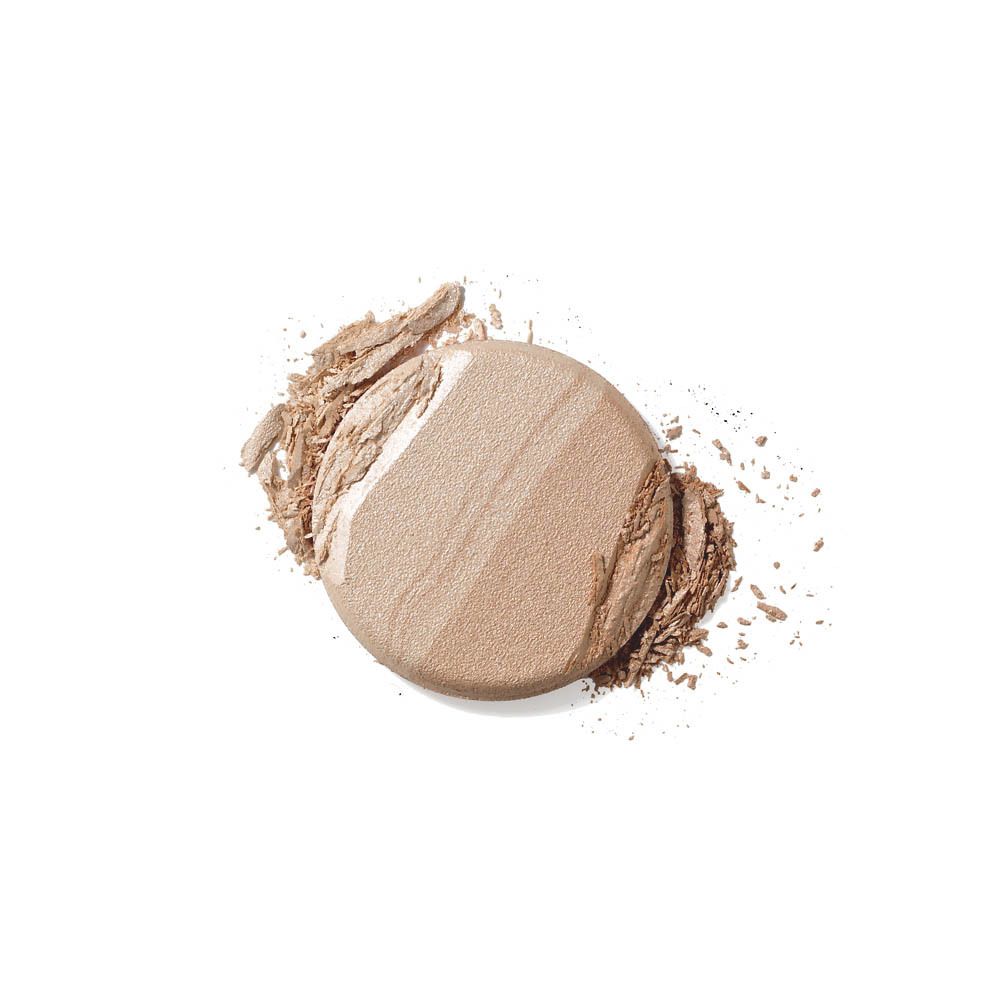 Highlighter rond avec trois teintes, partiellement émietté. Tons clairs et foncés. Sur fond blanc.