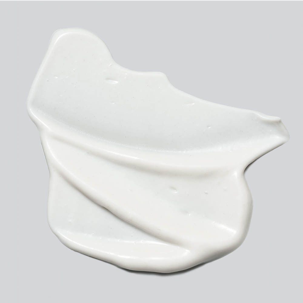 Weißes Creme-Produkt auf grauem Hintergrund. Textur sichtbar.