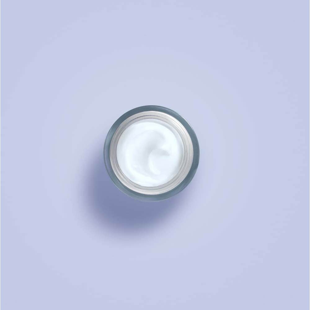 Vue de dessus de la crème dans un pot. La crème est blanche.