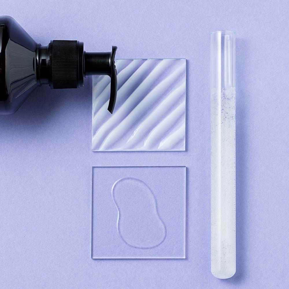 Échantillon de produit sur plaques de verre carrées. Shampooing et sérum.