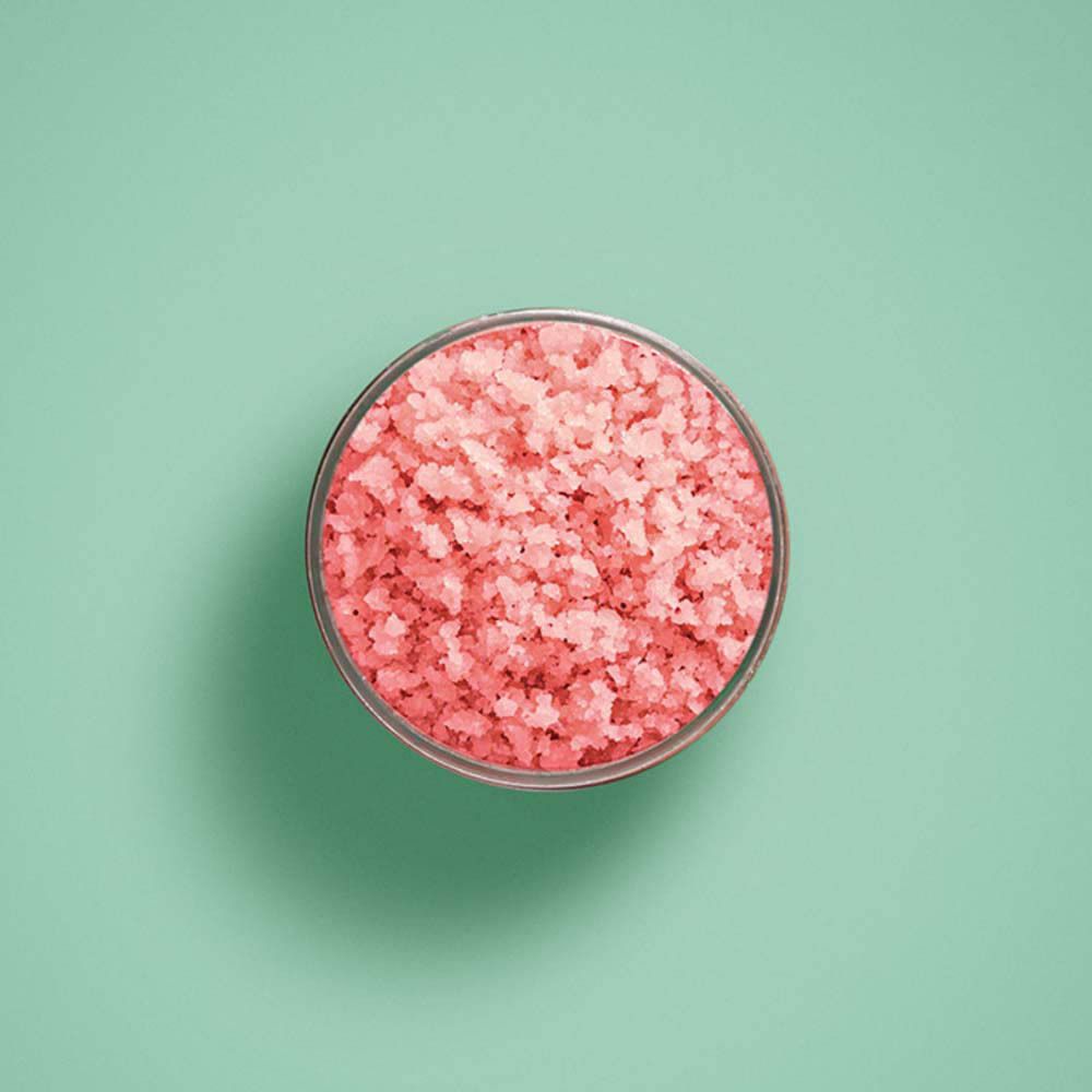 Vue de dessus du sel exfoliant dans un pot. Couleur rose.