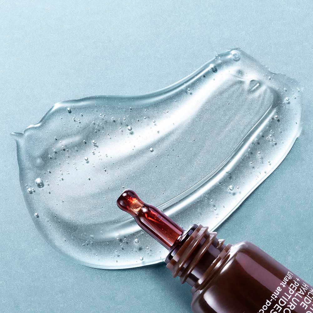 Sérum gel sur fond bleu. Goutte avec applicateur. Texte du produit: Hyaluronic Acid + Peptides. Eye Contour.