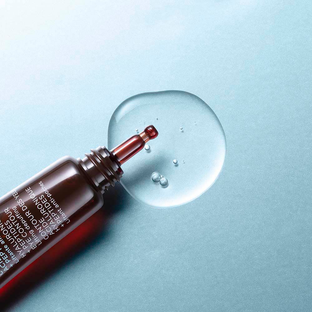 Sérum gel sur fond bleu. Goutte avec applicateur. Texte du produit: Hyaluronic Acid + Peptides. Eye Contour.