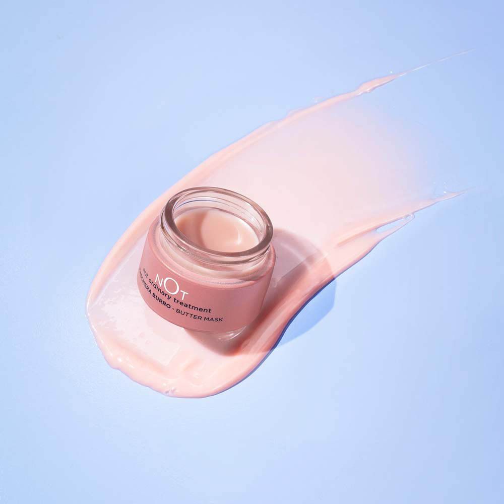 Crème rose sur fond bleu. Pot avec inscription : NOT, MASCHERA BURRO - BUTTER MASK.