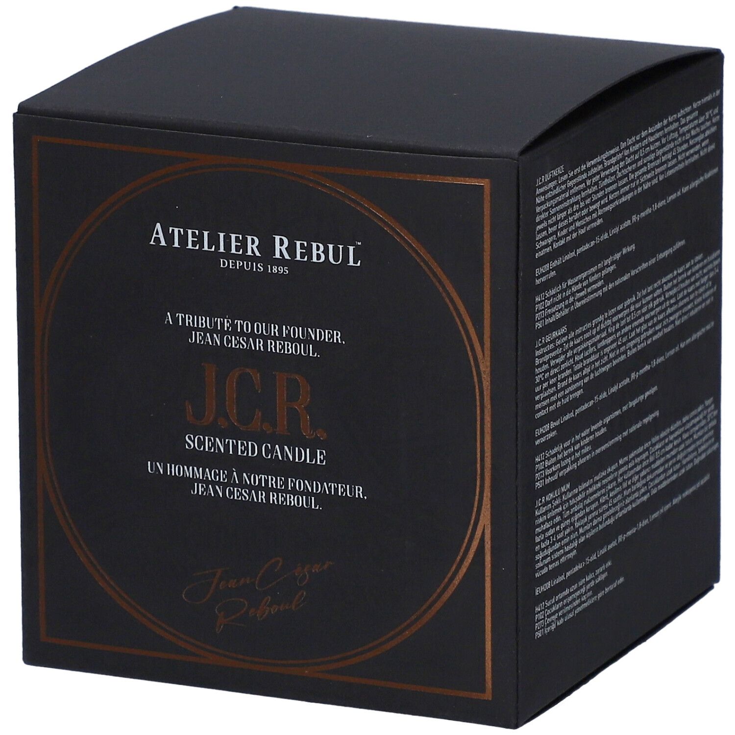 Schwarze quadratische Schachtel mit goldfarbenem Aufdruck. Text: Atelier Rebul, J.C.R. Scented Candle. Signatur.