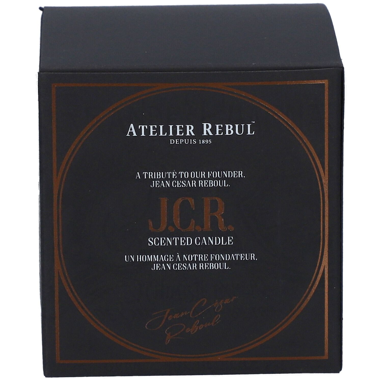 Schwarze quadratische Schachtel mit goldfarbenem Aufdruck. Text: Atelier Rebul, J.C.R. Scented Candle. Signatur.