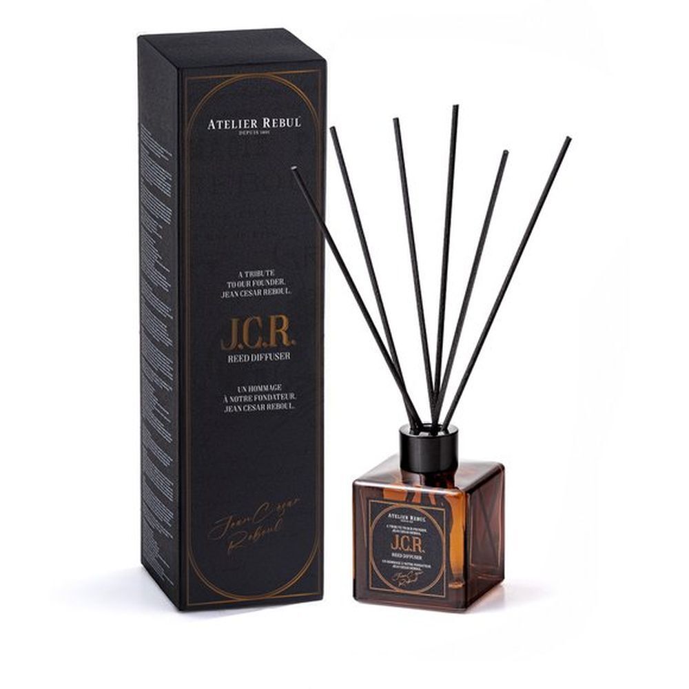 Produit avec boîte noire et flacon en verre. Bâtonnets noirs sortent du flacon.