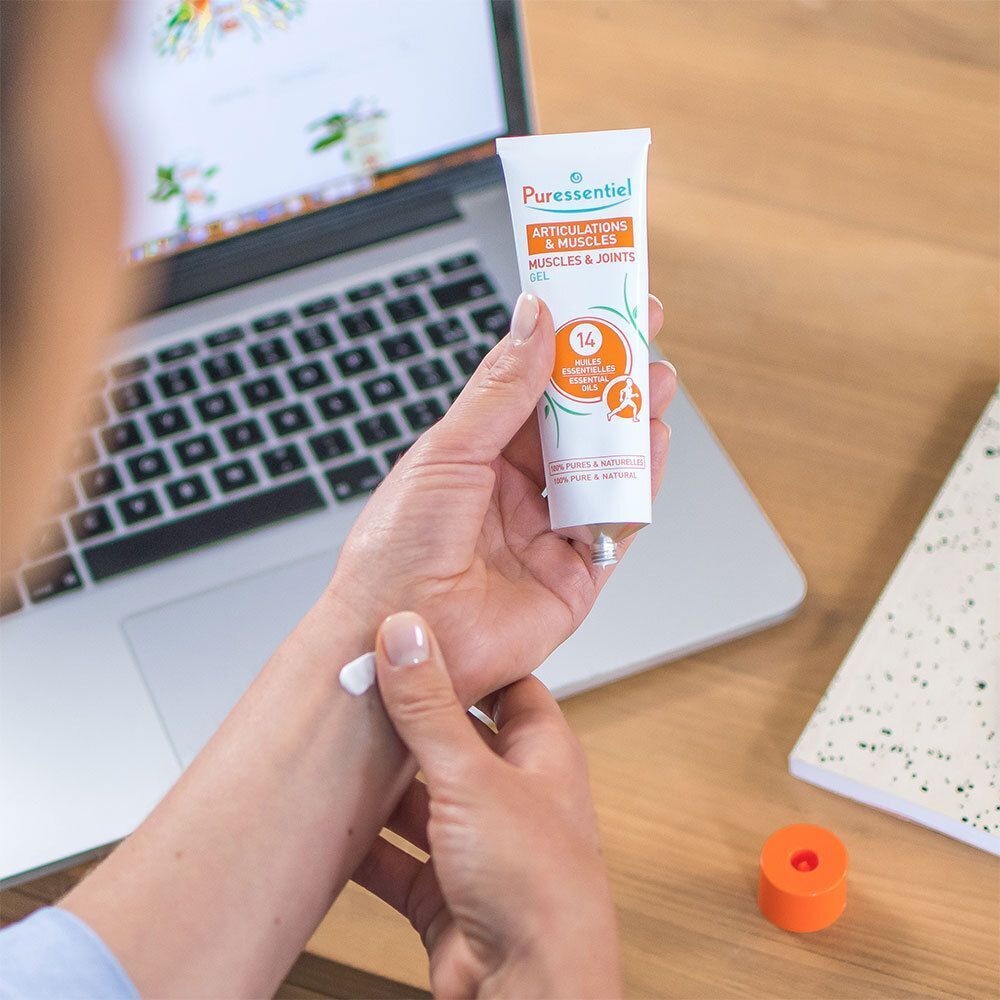 Person hält Tube. Produktname und Logo sichtbar. Gel für Gelenke und Muskeln. Anwendung auf dem Handgelenk.