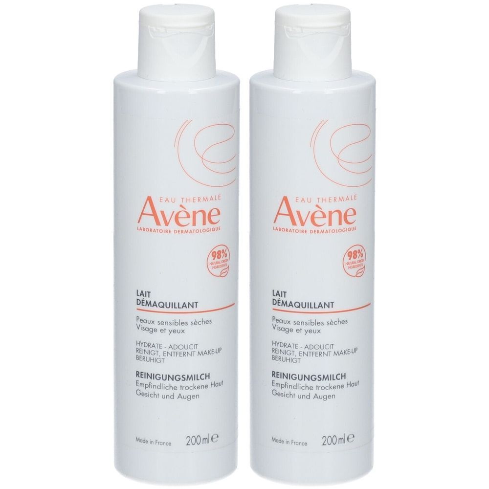 Deux flacons blancs avec texte rouge. Inscription: Avène, Lait démaquillant pour peaux sensibles.