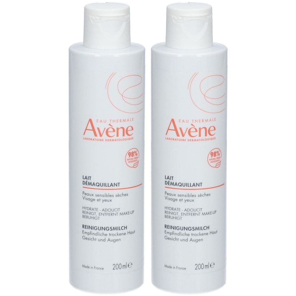Deux flacons blancs avec texte rouge. Inscription: Avène, Lait démaquillant pour peaux sensibles.