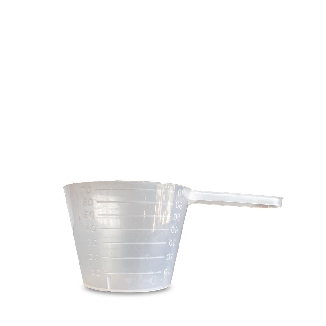 Mesurette transparente avec poignée et graduation en ml. Vue rapprochée.