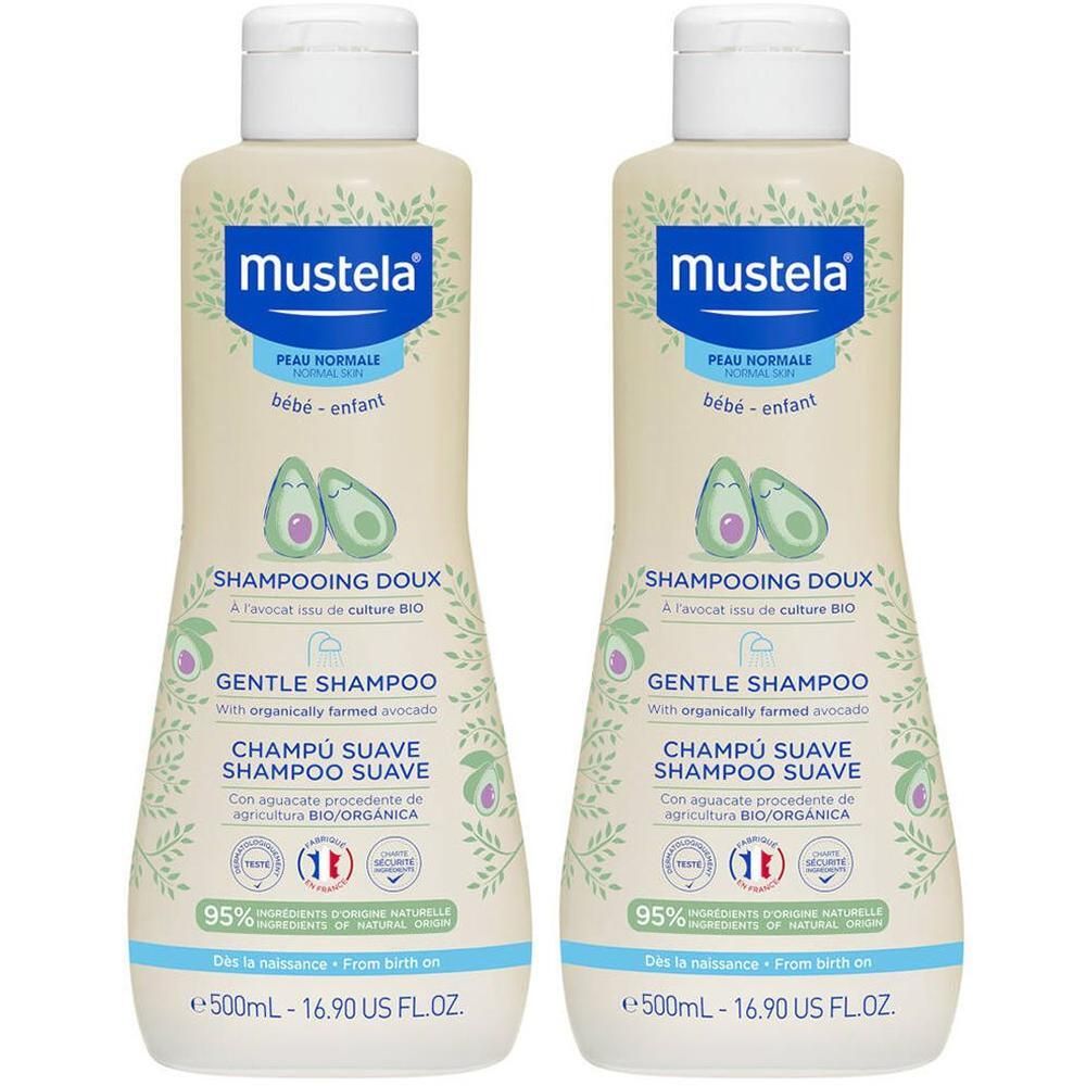 Deux flacons de shampooing Mustela. Flacons beiges avec bouchons blancs. Étiquettes bleues avec texte et illustrations d'avocats.