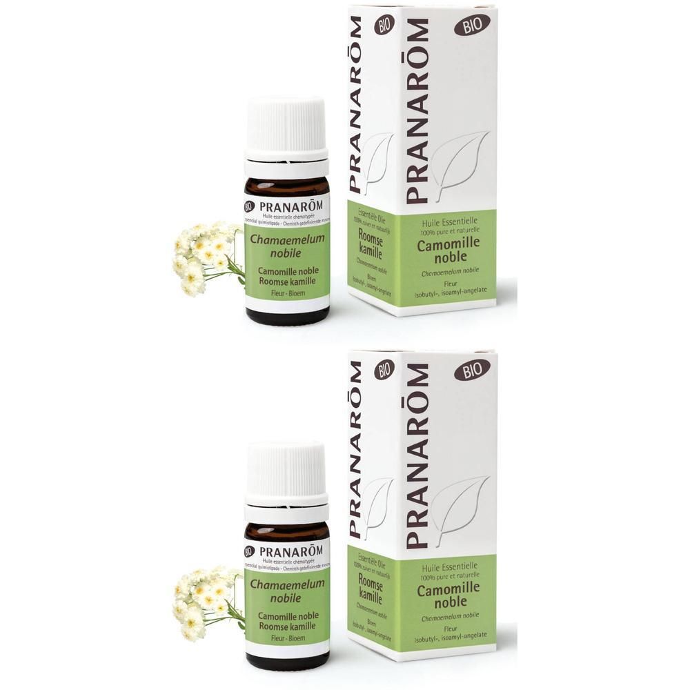 Zwei Flaschen und Schachteln von PRANAROM. Braune Glasflaschen mit weißem Deckel. Weiße Schachteln mit grüner Schrift und Logo.