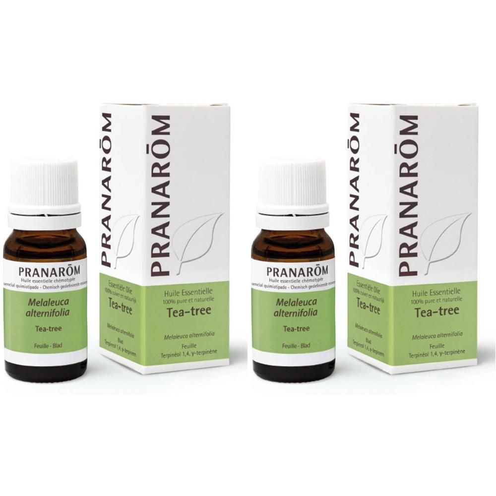 Braune Glasflasche mit weißem Deckel und Etikett in weißer Schachtel. Aufschrift: PRANAROM, Tea-tree.