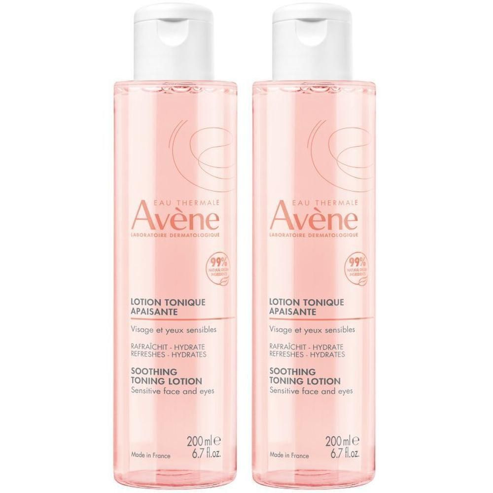 Zwei Flaschen Avène Lotion. Rosa Flüssigkeit, weißer Deckel. Beschriftung: Lotion tonique apaisante, Visage et yeux sensibles.