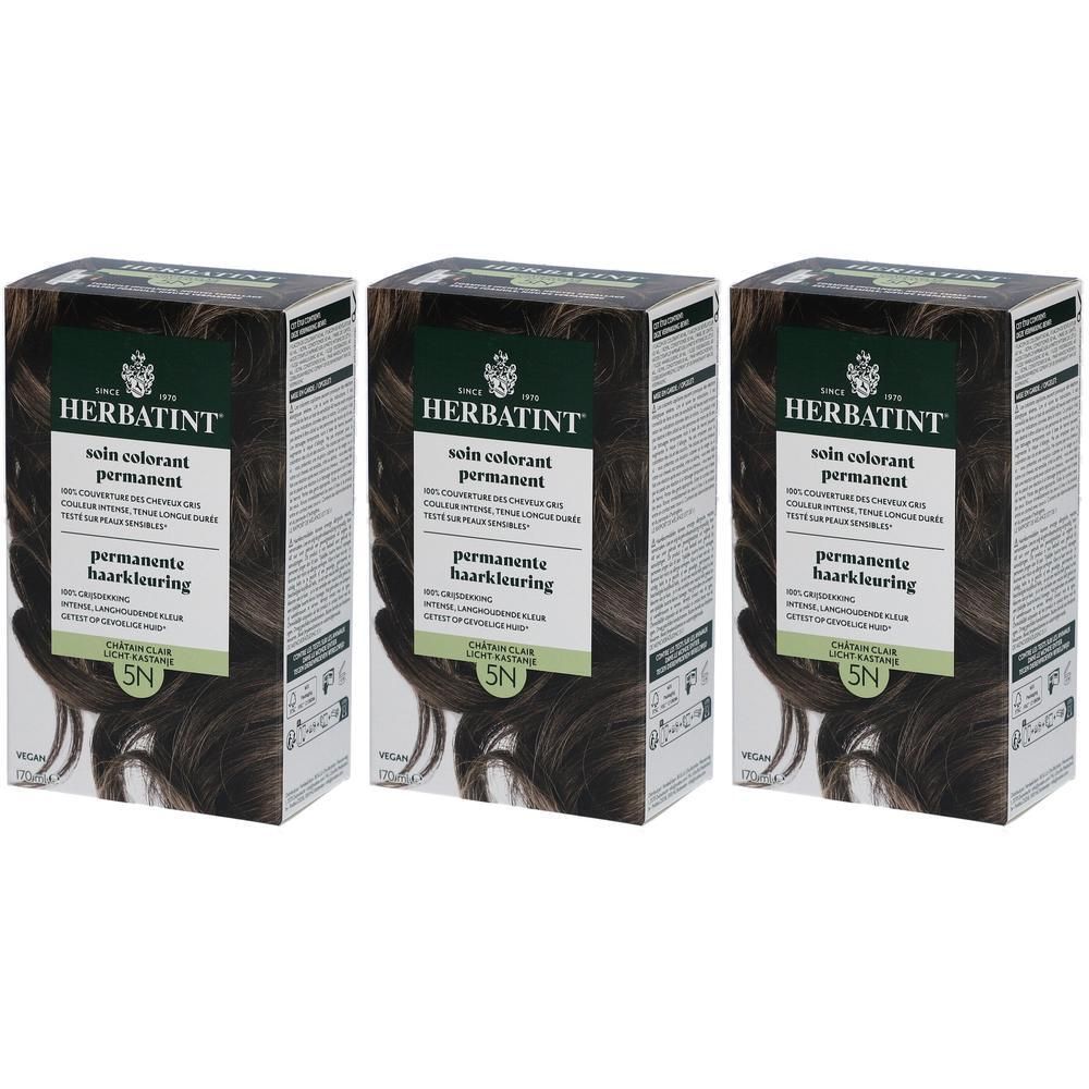 Drei Schachteln Herbatint Pflege Permanente Coloration. Dunkelbraune Verpackung mit Produktinformationen und Haarsträhne.