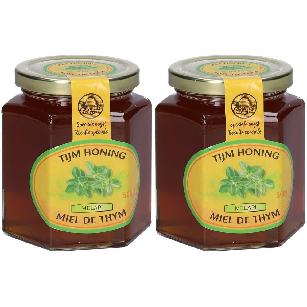 Zwei Gläser Thymianhonig. Sechseckige Form, goldener Deckel, gelbes Etikett mit Pflanzenmotiv und Schriftzug.