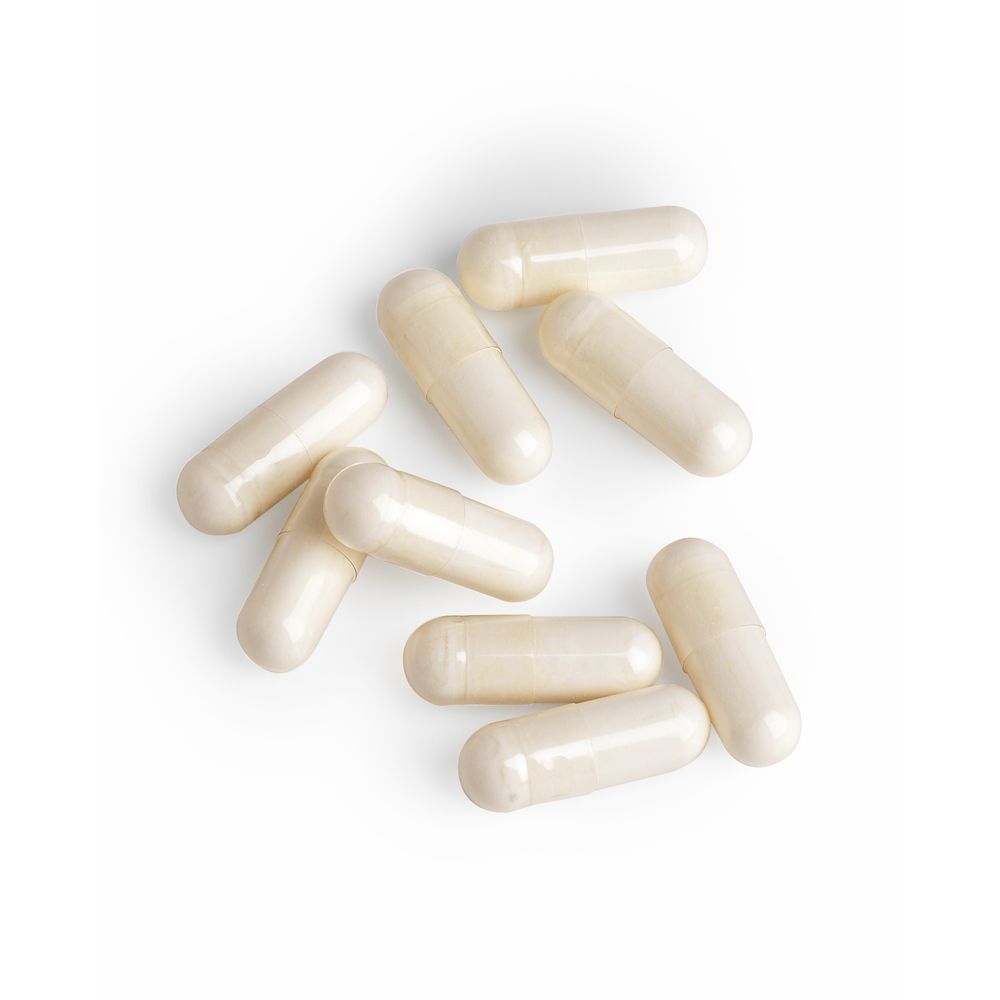 Neun cremefarbene Kapseln auf weißem Hintergrund. Keine Verpackung sichtbar.