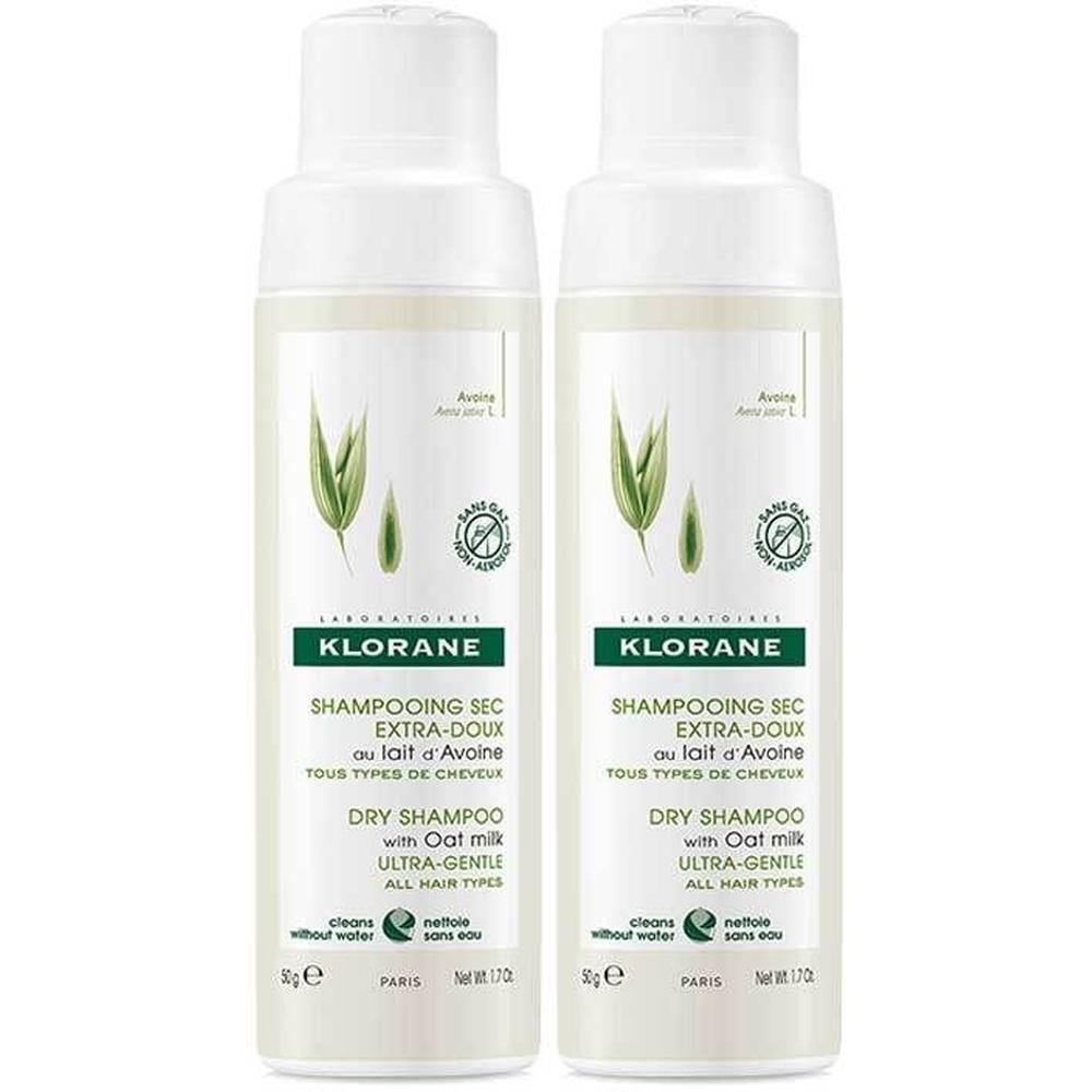 Zwei weiße Sprühflaschen. Aufschrift: KLORANE, Trockenshampoo Extramild mit Hafermilch. Grün-weiße Etiketten mit Logo und Text.