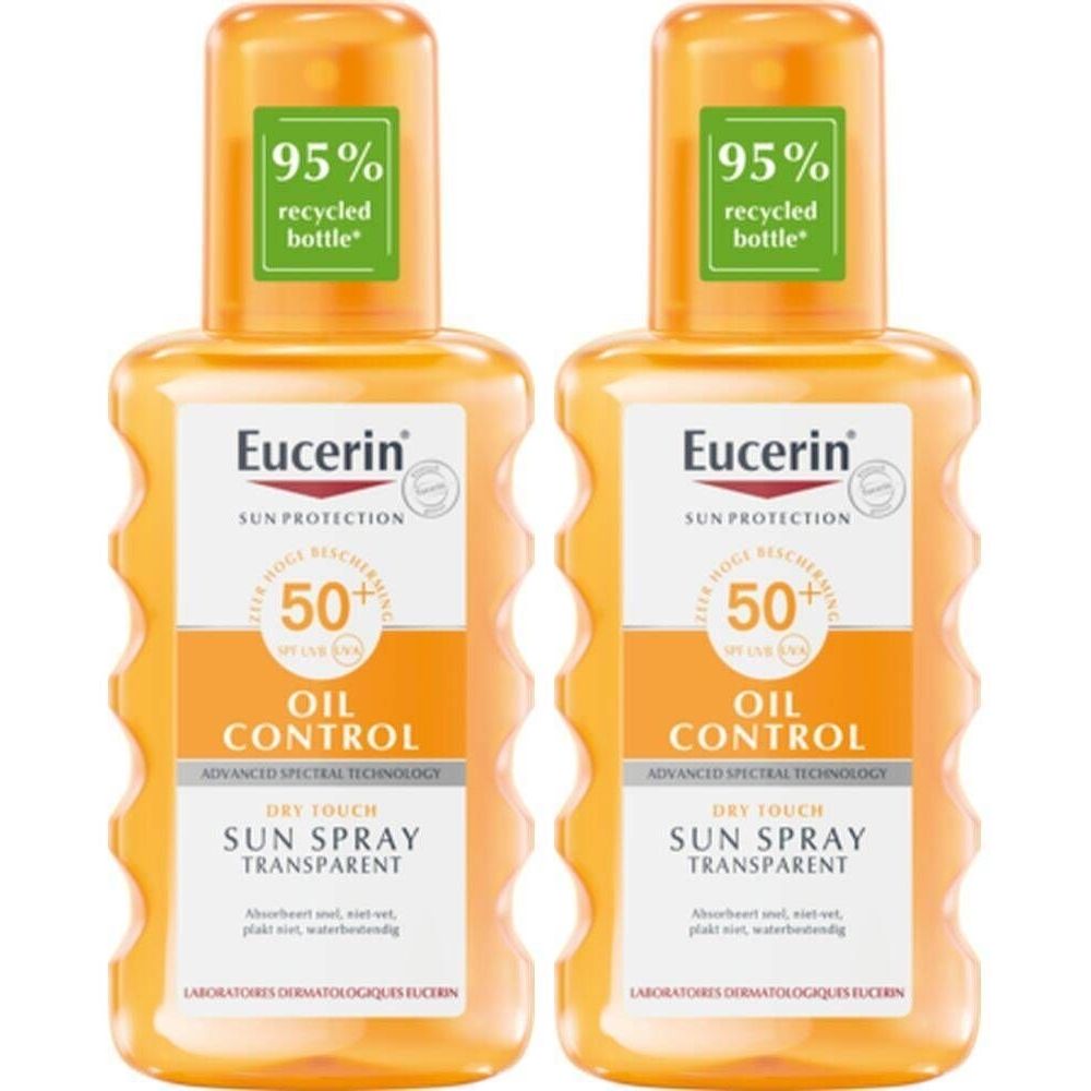 Deux flacons de Eucerin Sun Spray Transparent LSF 50. Bouchons orange, étiquettes avec informations produit et indication de bouteille recyclée.