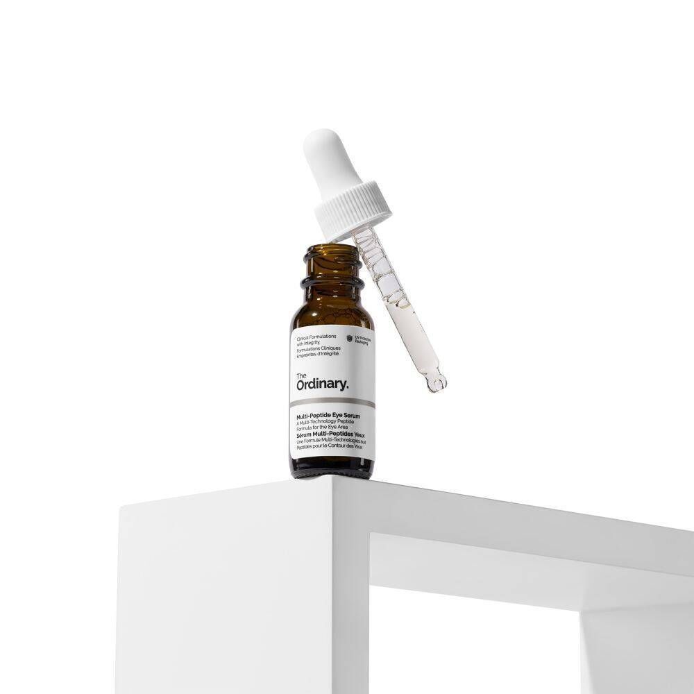 Un flacon de The Ordinary Multi-Peptide Eye Serum avec pipette, sur un socle blanc.