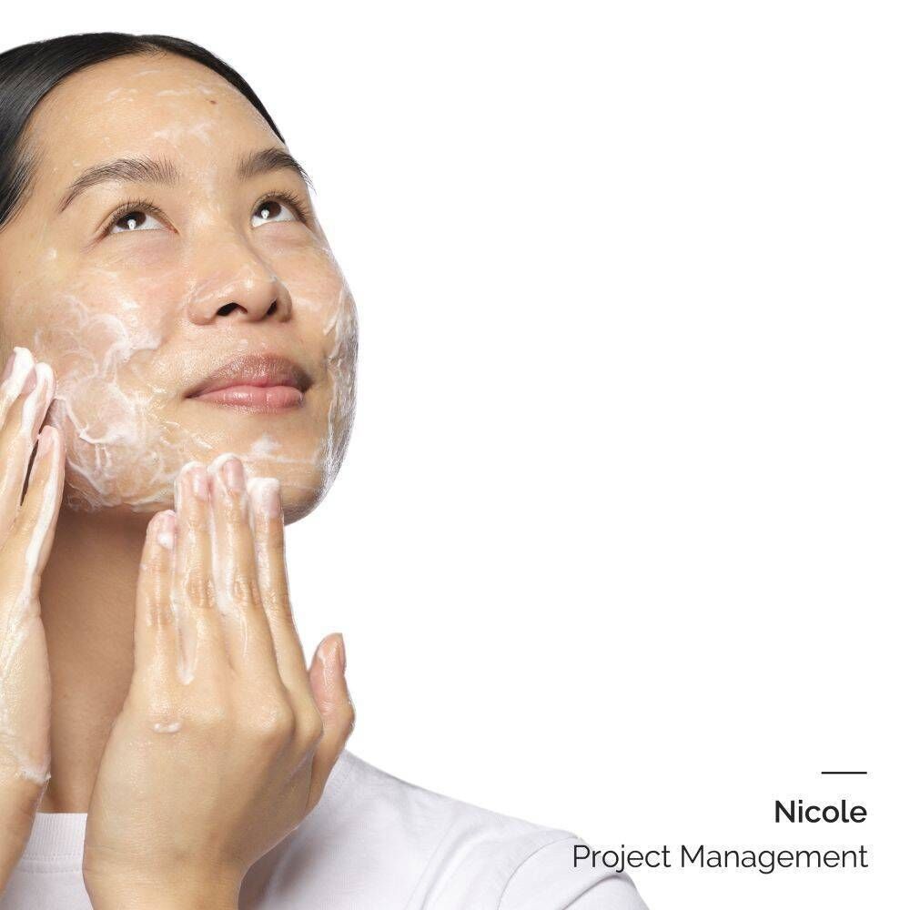 Une femme applique un nettoyant moussant sur son visage.