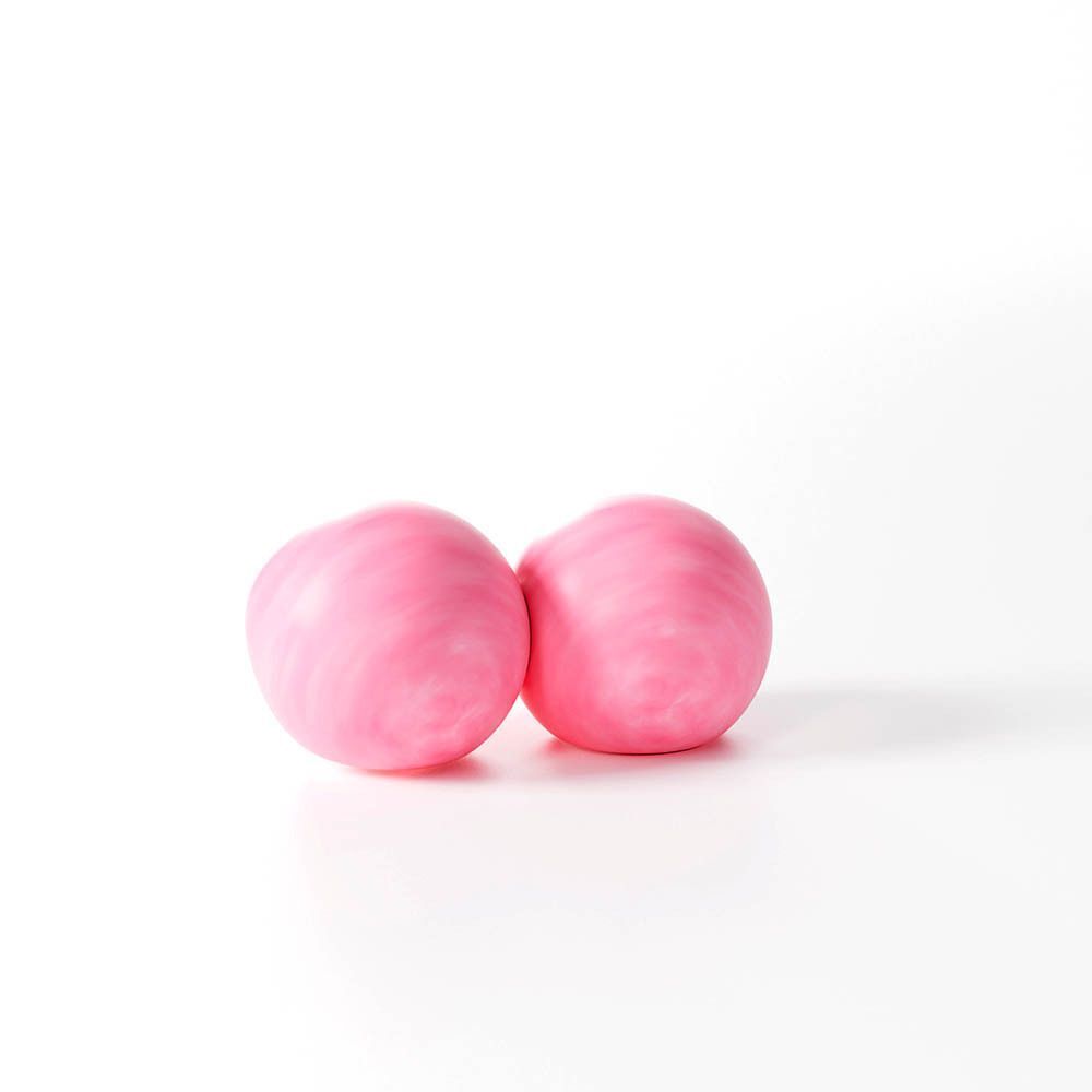 Zwei rosa Ohrstöpsel aus Naturwachs, medium, mit sichtbaren Wachswirbeln.