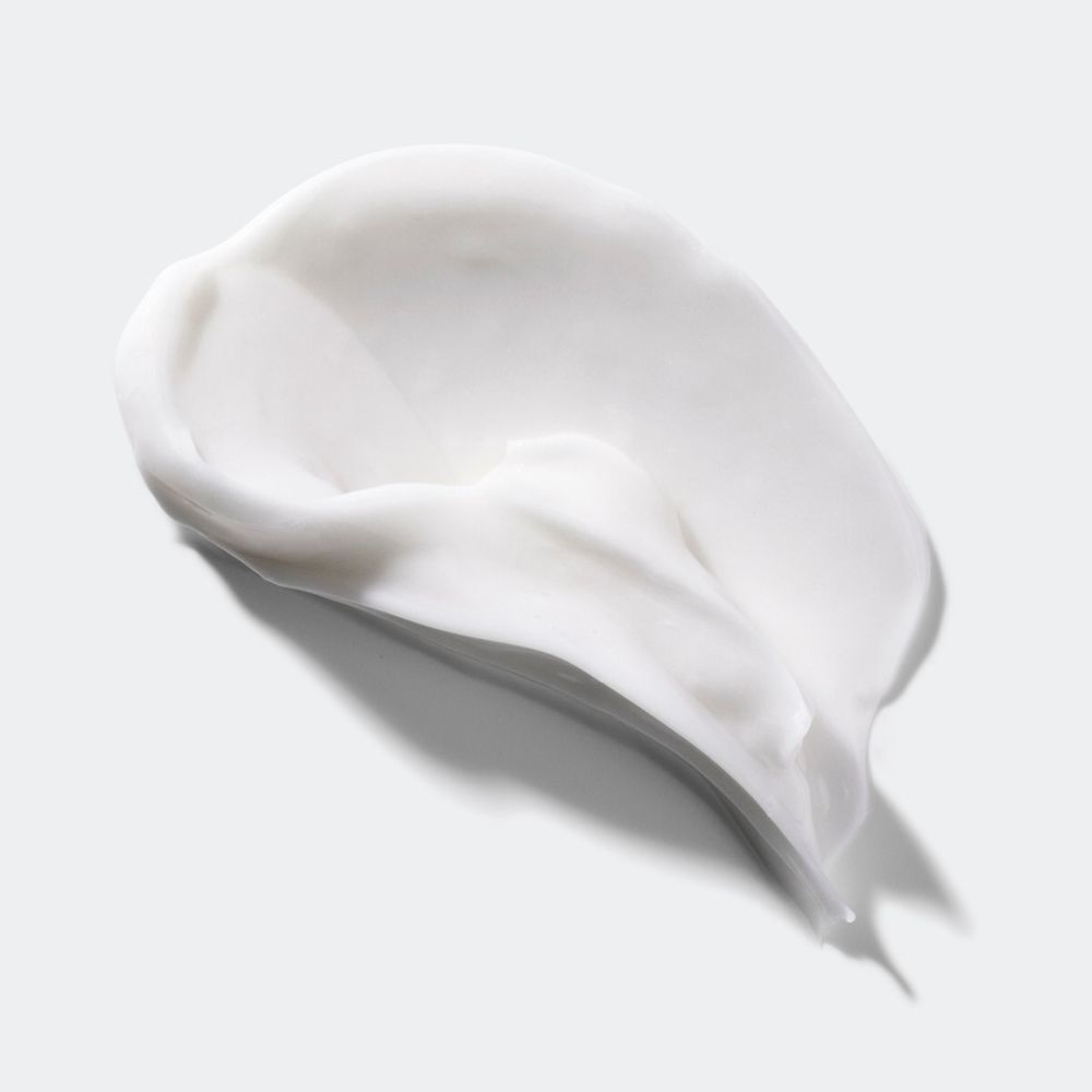 Une texture de crème blanche étalée sur une surface lisse.