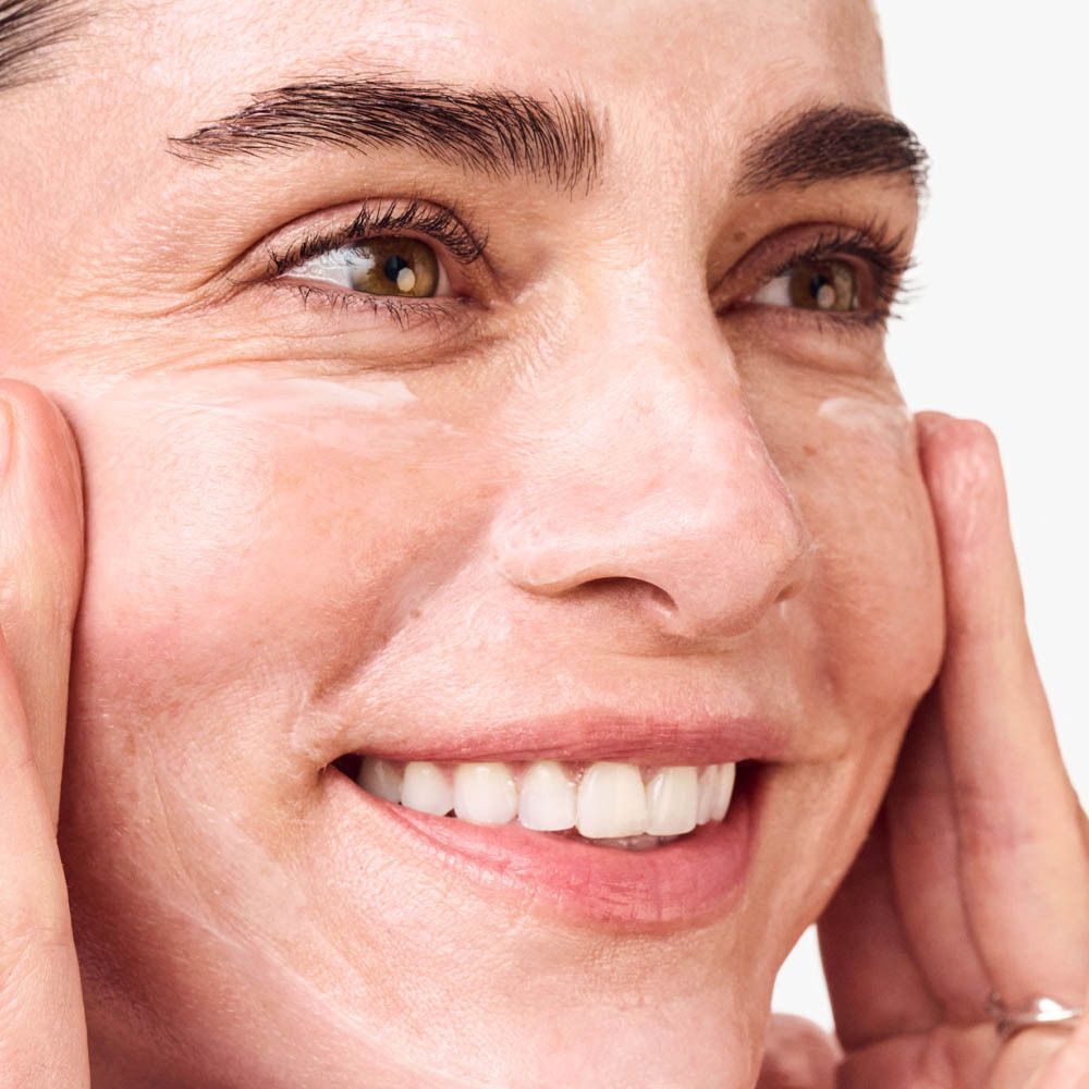 Une femme tenant un pot Clinique Smart Clinical Repair™.