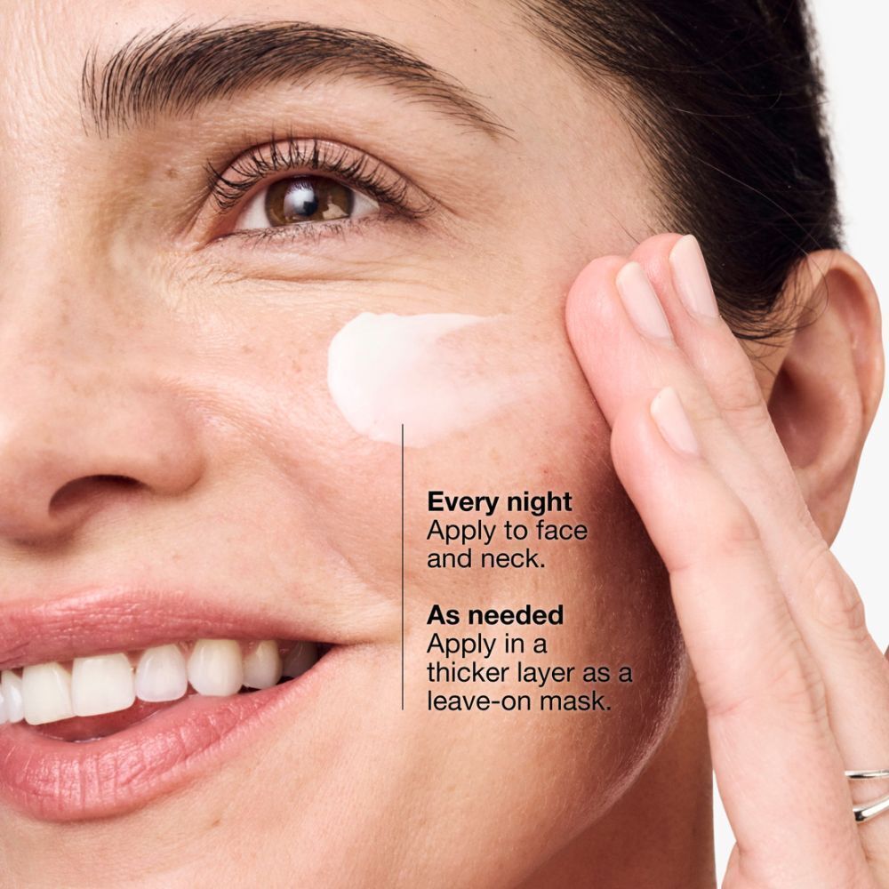 Une femme appliquant la crème Clinique Smart Clinical Repair™ sur son visage.
