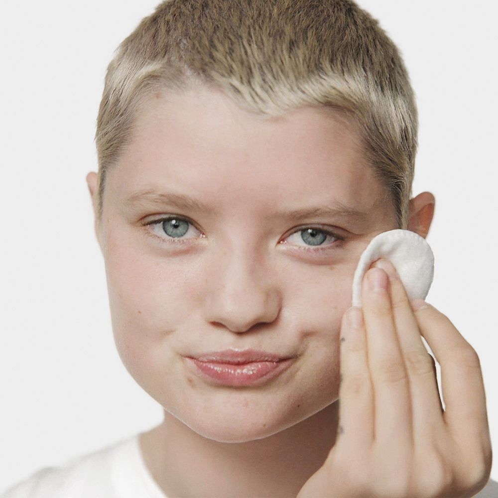 Une personne utilise un coton avec Clinique Clarifying Lotion.