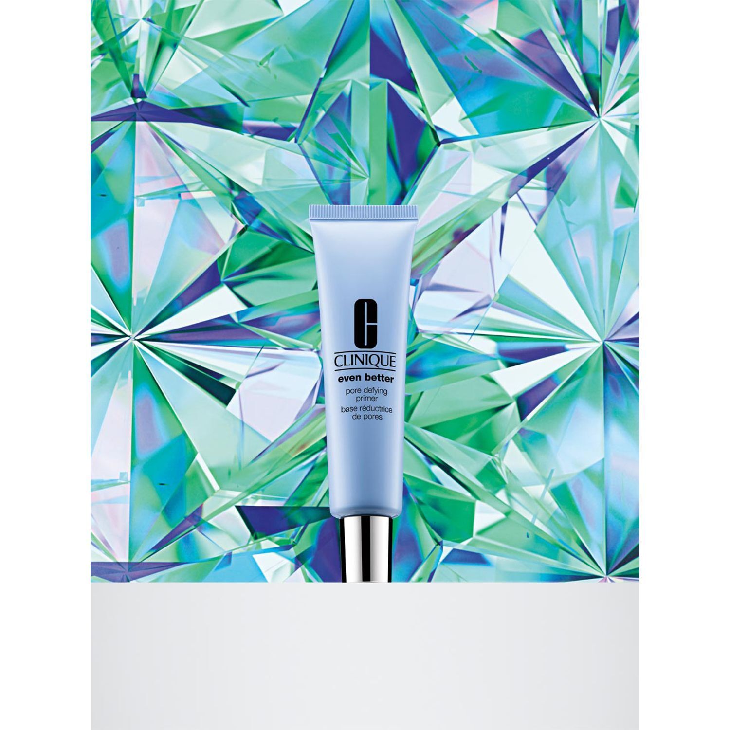 Un tube de CLINIQUE Even Better Pore Defying Primer devant un fond vert à facettes.
