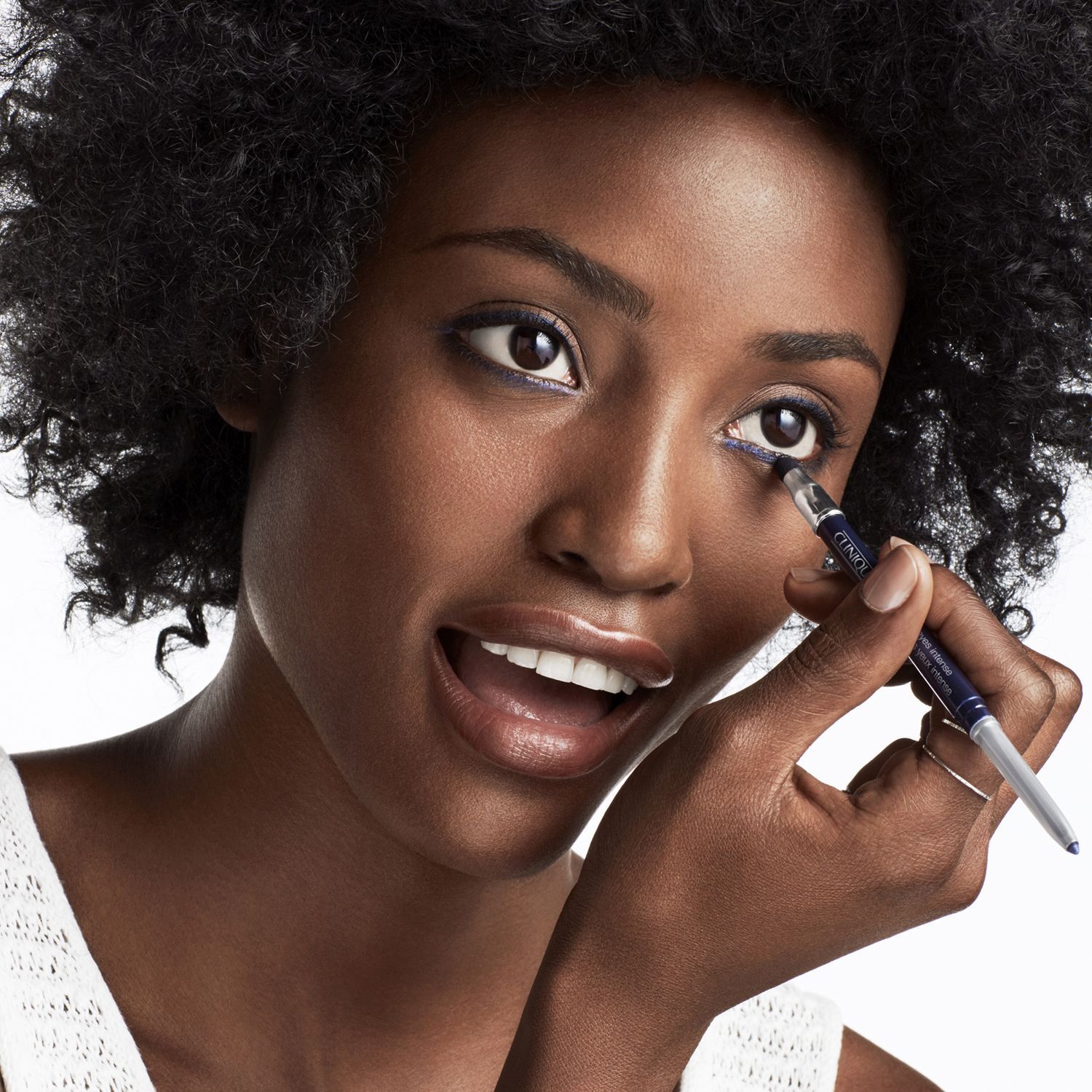 Frau mit dunklem Hautton trägt blauen Eyeliner mit einem Clinique Stift auf.