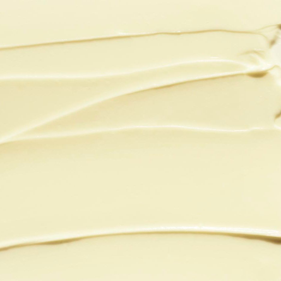 Gros plan de la texture crémeuse de la crème mains et cuticules Deep Comfort CLINIQUE. Application lisse et ondulée.